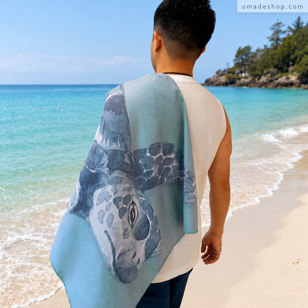 Umade 海洋微笑系列萬用快乾巾海龜款，站在沙灘上展示海龜圖案快乾巾，適合海邊玩水使用。SUP、游泳、衝浪、潛水、日光浴都適合，